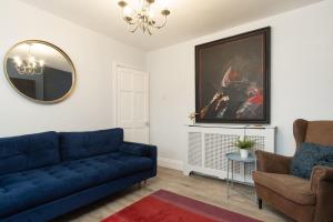 a living room with a blue couch and a mirror at Stratford House in Braunstone