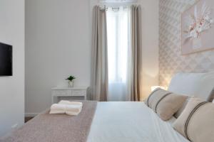 カンヌにあるLe petit princeの白いベッドルーム(大きな白いベッド1台、窓付)