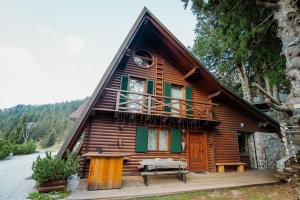 a log cabin with a porch and a balcony at Chalet Alpinka in Cerklje na Gorenjskem