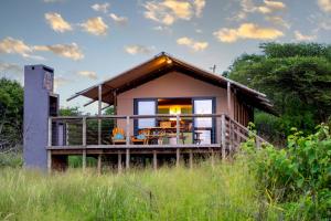 ein kleines Haus mit einer Veranda und einer Terrasse in der Unterkunft AfriCamps at White Elephant Safaris in Pongola Game Reserve