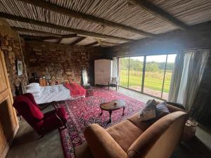 a living room with a bed and a couch at Kwaggaskop Farm Kliphuis in Dullstroom