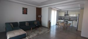 un soggiorno con divano e tavolo e una cucina di Logement Chic, résidence azaléa - Alger a Draria