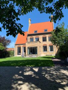 a large brick building with an orange roof at The westhouse in Middelkerke