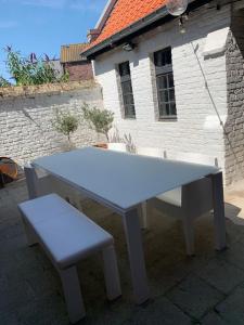 a white ping pong table and a pair of benches at The westhouse in Middelkerke