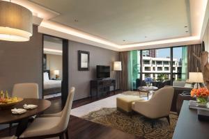 a living room with a couch and a dining room at Siam Kempinski Hotel Bangkok - SHA Extra Plus Certified in Bangkok