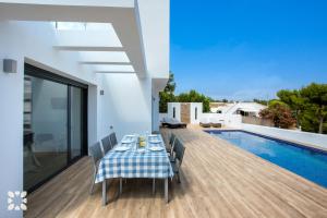 una sala da pranzo con tavolo e piscina di Villa Aruba by Abahana Villas a Benissa