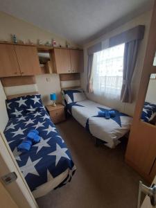 um quarto com 2 camas e uma janela em Seaside caravan Hoburne Naish Holiday Park Naish Common 83 em New Milton