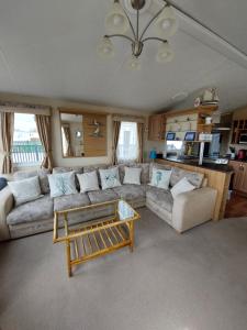 uma sala de estar com um sofá e uma mesa em Seaside caravan Hoburne Naish Holiday Park Naish Common 83 em New Milton