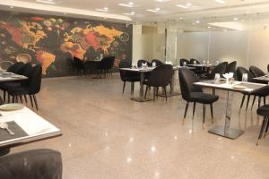 a restaurant with tables and chairs and a large mural at Hotel maxsun gwalior in Gwalior