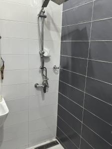 a shower with a gray and white tile wall at Résidences Salsia - Toubab Dialaw - Appt RDC in Rufisque