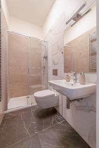 een badkamer met een toilet, een wastafel en een douche bij Historic City Center Deer Suite by Rentez in Praag