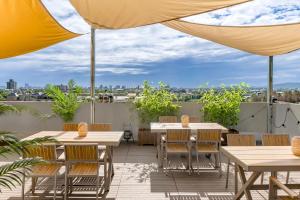 a patio with tables and chairs and an umbrella at H& Kuma B&B in Jian