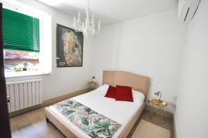 een slaapkamer met een bed met rode kussens en een raam bij La casa del papavero in Lucca