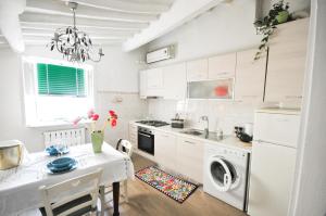 een witte keuken met een tafel en een wasmachine bij La casa del papavero in Lucca