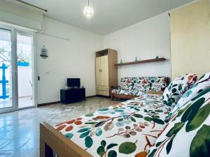 1 Schlafzimmer mit einem Bett mit Blumendecke in der Unterkunft il Profumo del Mare a 150 mt dalla spiaggia bandiera blu in Torre Ovo