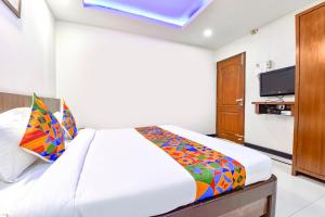 a bedroom with a bed and a flat screen tv at FabHotel Shakti Palace in Ponda