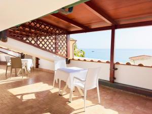 una sala da pranzo con tavolo, sedie e vista sull'oceano di Hotel Marconi a Sperlonga