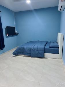 - une chambre bleue avec un lit dans une chambre bleue dans l'établissement D cateleya homestay, à Beranang
