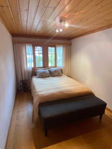 a bedroom with a large bed with a wooden ceiling at Lovely 3 bedroom apartment in Schönried