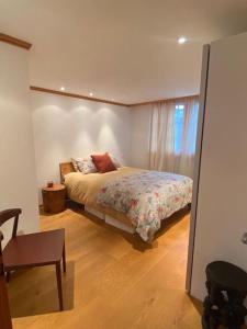 um quarto com uma cama e uma cadeira em Lovely 3 bedroom apartment em Schönried