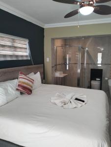 una camera con un letto bianco e un accappatoio. di Sunrise Boutique Hotel a Witbank