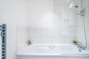 een badkamer met een bad en een douche bij InSpires House Contractors, families, Wifi, Free Parking Town Centre in Hemel Hempstead