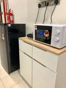a microwave sitting on top of a counter next to a refrigerator at Andiana Hotel & Lodge - Kota Bharu City Centre in Kota Bharu +29 photos