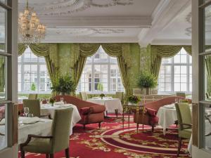 - une salle à manger avec des tables, des chaises et des fenêtres dans l'établissement The Goring, à Londres