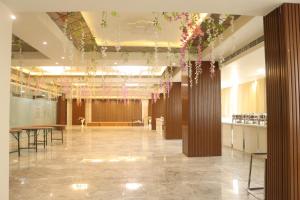 a lobby with tables and flowers hanging from a ceiling at Hotel maxsun gwalior in Gwalior