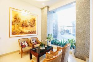 a living room with a table and chairs and a large window at Empress Dalat - Sky View Hotel in Da Lat