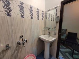 y baño con lavabo y espejo. en Stay Inn Eastwood Guest House, en Shillong