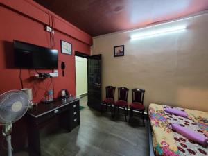シロンにあるStay Inn Eastwood Guest Houseのベッド、デスク、椅子が備わる客室です。