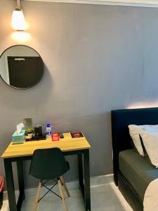 Cette chambre comprend un bureau, un lit et un miroir. dans l'établissement Andiana Hotel & Lodge - Kota Bharu City Centre, à Kota Bharu