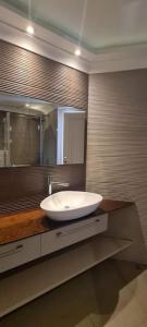 La salle de bains est pourvue d'un lavabo blanc et d'un miroir. dans l'établissement Leonardo sea view residence, à Bat Yam