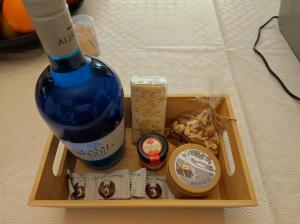 ein Tablett mit einer Flasche Wein und einigen Snacks in der Unterkunft Comfort Beach house in Nazaré