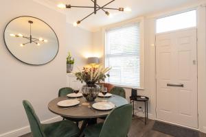 a dining room with a table and chairs and a mirror at Stapenhill House in Burton upon Trent