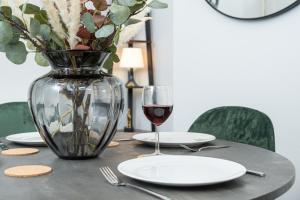 a table with a vase and a glass of wine at Stapenhill House in Burton upon Trent