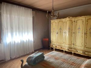 a living room with a yellow cabinet and a window at 1 camera matrimoniale con bagno privato - 1 double bedroom with private bathroom in Santa Margherita dʼAdige