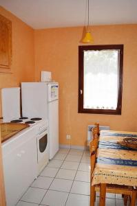 uma cozinha com um fogão e um frigorífico branco em EN PLEINE VERDURE AU CALME NON LOIN DU CENTREVILLE em La Tranche-sur-Mer