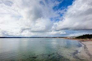 uma praia com céu nublado e a água em Radisson Blu Waterfront Hotel, Jersey em Saint Helier