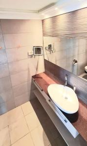 La salle de bains est pourvue d'un lavabo et d'un miroir. dans l'établissement Leonardo sea view residence, à Bat Yam