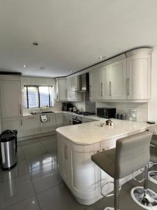 a kitchen with white cabinets and a large island at The Grey Mansion in Manchester