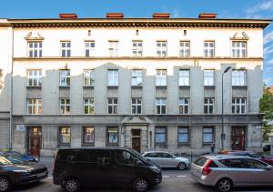a large building with cars parked in front of it at St Florian Apartments in Kraków