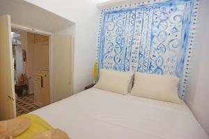 a bedroom with a bed with a blue and white headboard at Artistic Cycladic House Ano Syros in Ermoupoli