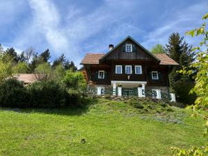 une maison au sommet d'une colline herbeuse dans l'établissement Chalet St Lorenzen, à Eibiswald