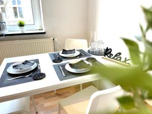 - une table blanche avec des assiettes et de la vaisselle dans l'établissement OS11 - 1-Zimmer Apartment in Osnabrück, à Osnabrück
