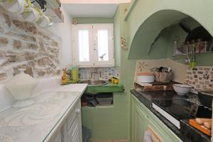 a kitchen with a sink and a stone wall at Artistic Cycladic House Ano Syros in Ermoupoli