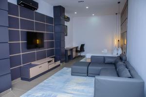 ein Wohnzimmer mit einem Sofa und einem TV in der Unterkunft G-Pinnacle Signature in Ilorin