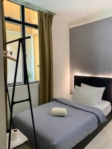 ein Schlafzimmer mit einem Bett mit einer Leiter neben einem Fenster in der Unterkunft Andiana Hotel & Lodge - Kota Bharu City Centre in Kota Bharu