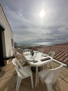 een witte tafel en stoelen op een balkon bij T4 Vue exceptionnelle sur le Golf du Lion in Cap d'Agde